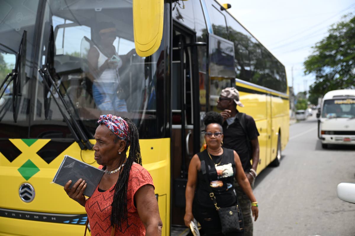 Passengers who boarded the bus in Port Antonio for the official launch of the Jamaica Urban Transit Company’s Route 710 service disembark in Yallahs Square, St Thomas, on September 23. The service provides scheduled transportation between Port Antonio a