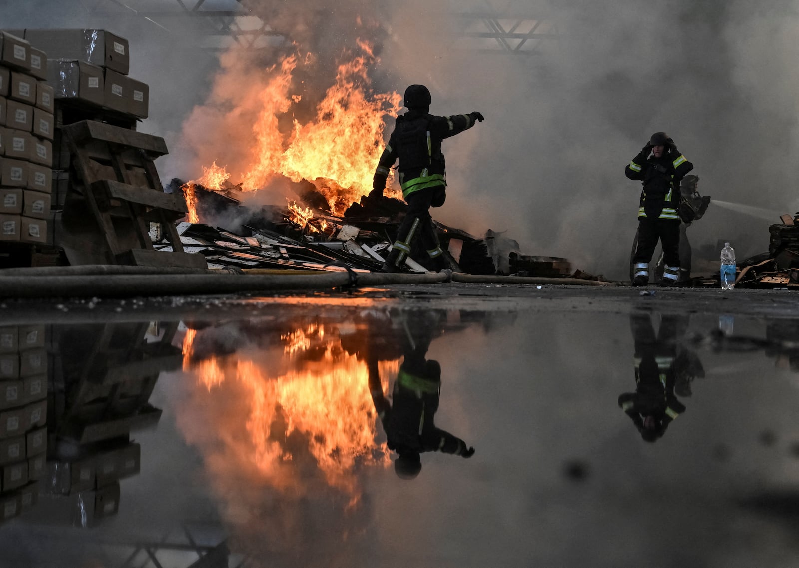 Bombeiros trabalham no local de um depósito de móveis atingido por um ataque de drone russo, em Zaporizhzhia, na Ucrânia Stringer/Reuters - 06.10.2026