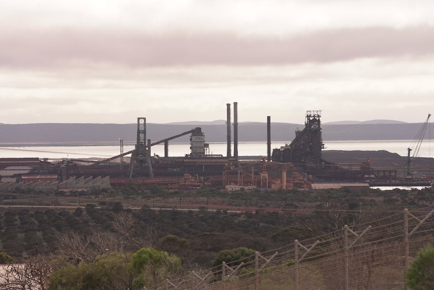 A photo of the Whyalla blast furnace facility, consisting of several buildings, railyards, buildings, towers and chimneys