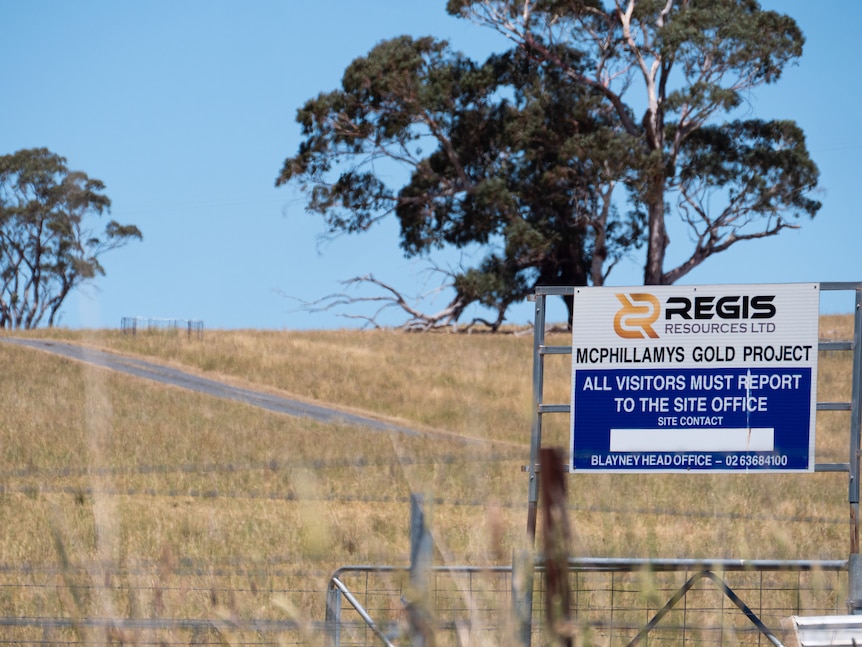 Farmland with paddocks, signs and fences.