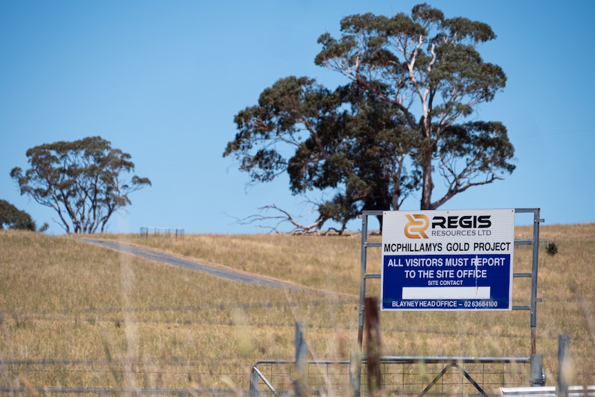 Farmland with paddocks, signs and fences.