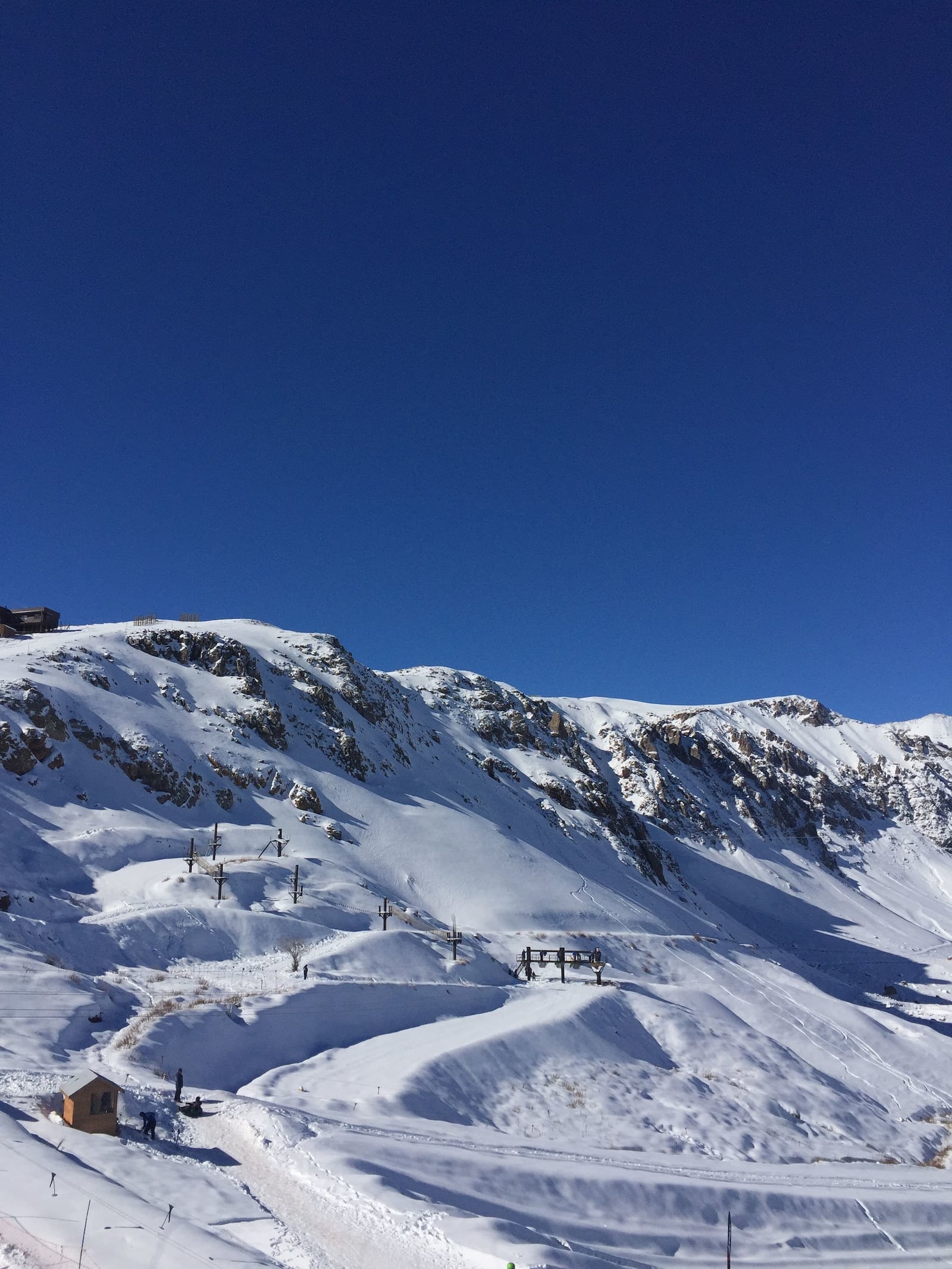 Montanhas andinas cobertas de neve sob céus azuis claros no Chile Breno Antonioli/Pexels