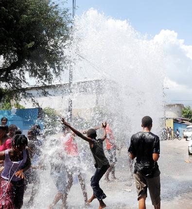 In this file photo, residents of Bundy Lane in St Andrew play in water from a burst underground National Water Commission pipe.